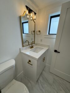 Modern bathroom with clean white vanity and gold fixtures by bellevuecleans, Bellevue local commercial cleaning services.