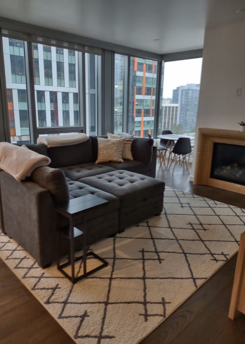 Clean and cozy Bellevue living room with sofa and rug by bellevuecleans – Recurring Cleaning Service