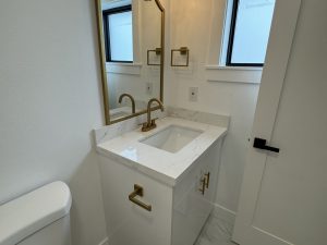 Modern bathroom with clean white vanity and gold fixtures by bellevuecleans, Bellevue local commercial cleaning services.