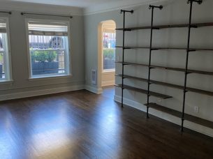Bright, freshly cleaned living room with hardwood floors and wall shelving, serviced by BellevueCleans — trusted cleaning services in Bellevue, WA.
